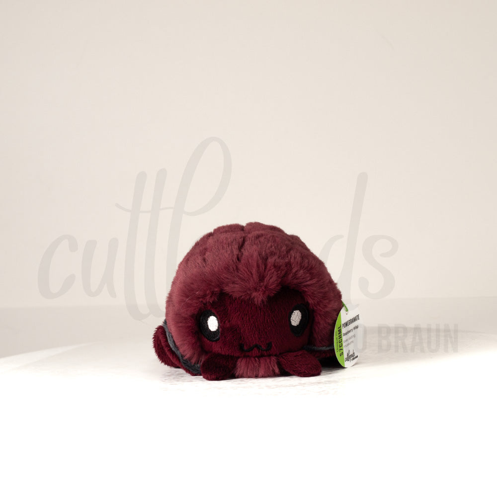 Front view of a cuttlepod plush toy, showcasing its unique form with large, cartoonish eyes, ruffled fins, and a cuddly, furry texture.