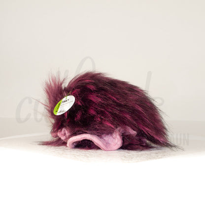 Slightly angled back view of a cuttlepod plush toy, highlighting two-tone ruffled fins, and a cuddly, furry body that comes to a soft point at the rear.