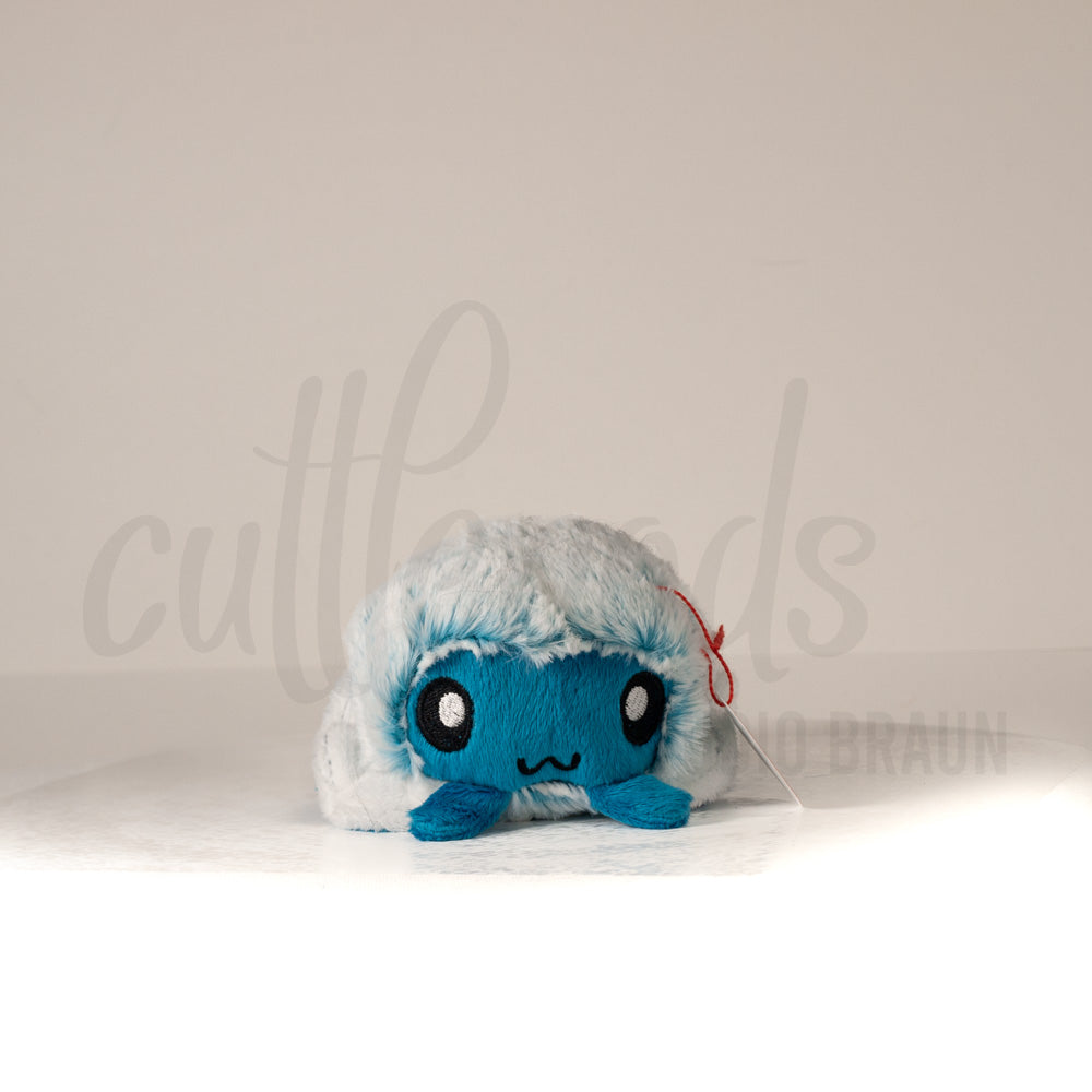 Front view of a cuttlepod plush toy, showcasing its unique form with large, cartoonish eyes, ruffled fins, and a cuddly, furry texture.