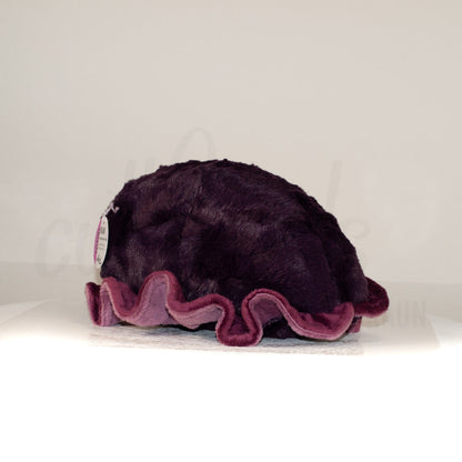 Slightly angled back view of a cuttlepod plush toy, highlighting two-tone ruffled fins, and a cuddly, furry body that comes to a soft point at the rear.