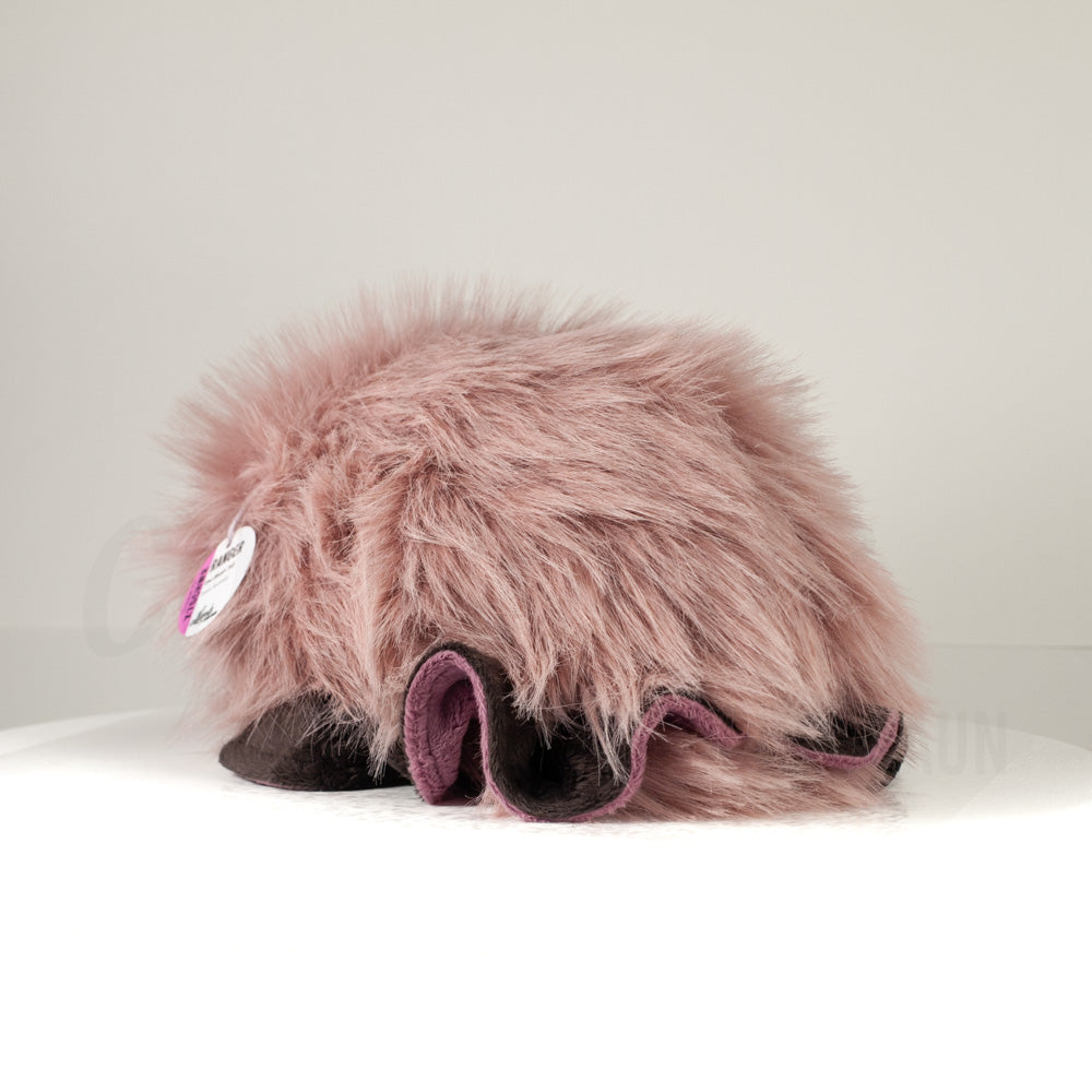 Slightly angled back view of a cuttlepod plush toy, highlighting two-tone ruffled fins, and a cuddly, furry body that comes to a soft point at the rear.