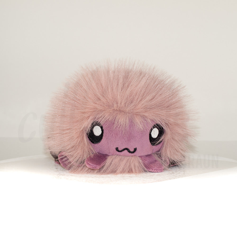 Front view of a cuttlepod plush toy, showcasing its unique form with large, cartoonish eyes, ruffled fins, and a cuddly, furry texture.