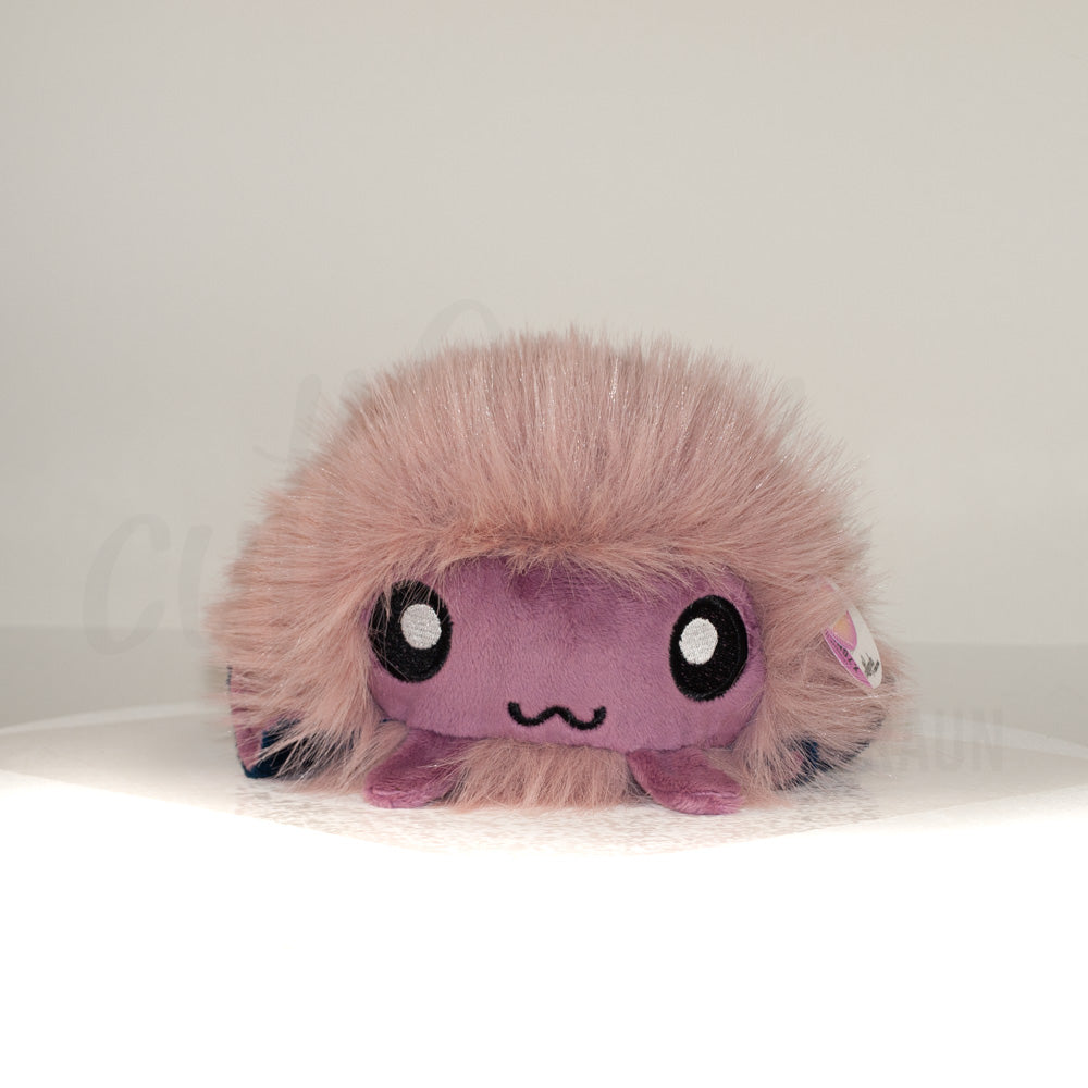 Front view of a cuttlepod plush toy, showcasing its unique form with large, cartoonish eyes, ruffled fins, and a cuddly, furry texture.