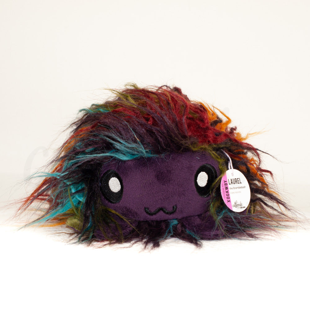 Front view of a cuttlepod plush toy, showcasing its unique form with large, cartoonish eyes, ruffled fins, and a cuddly, furry texture.