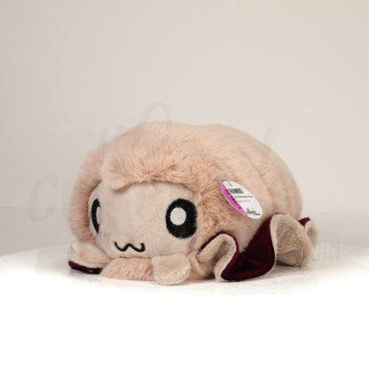 Front view of a cuttlepod plush toy, captured at a slight angle to highlight its charming features: large, cartoonish eyes, ruffled fins, and a cuddly, furry texture.