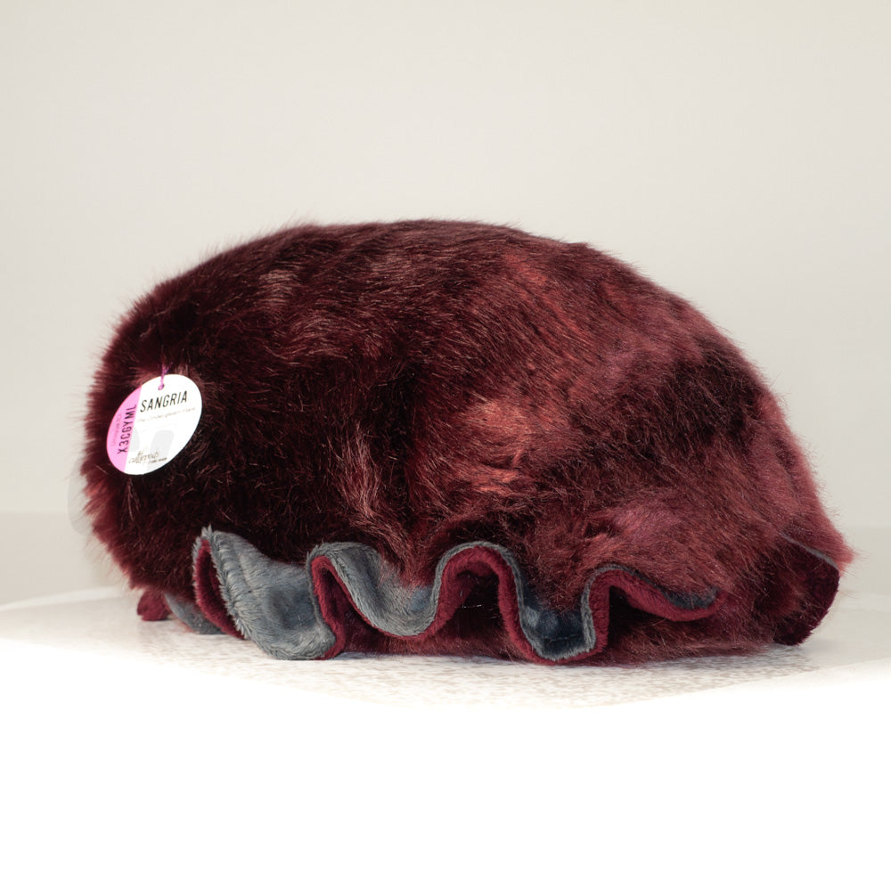 Slightly angled back view of a cuttlepod plush toy, highlighting two-tone ruffled fins, and a cuddly, furry body that comes to a soft point at the rear.