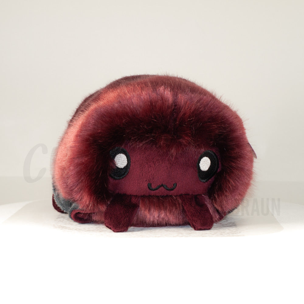 Front view of a cuttlepod plush toy, showcasing its unique form with large, cartoonish eyes, ruffled fins, and a cuddly, furry texture.