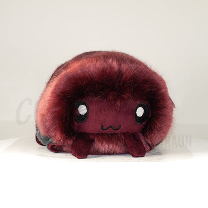 Front view of a cuttlepod plush toy, showcasing its unique form with large, cartoonish eyes, ruffled fins, and a cuddly, furry texture.