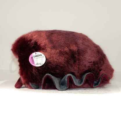 Side profile view of a cuttlepod plush toy, showcasing two-tone ruffled fins, and a cuddly, furry body.