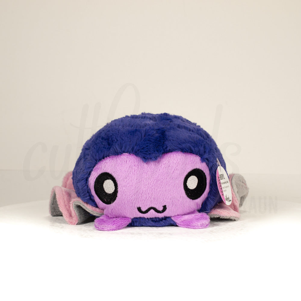 Front view of a cuttlepod plush toy, showcasing its unique form with large, cartoonish eyes, ruffled fins, and a cuddly, furry texture.