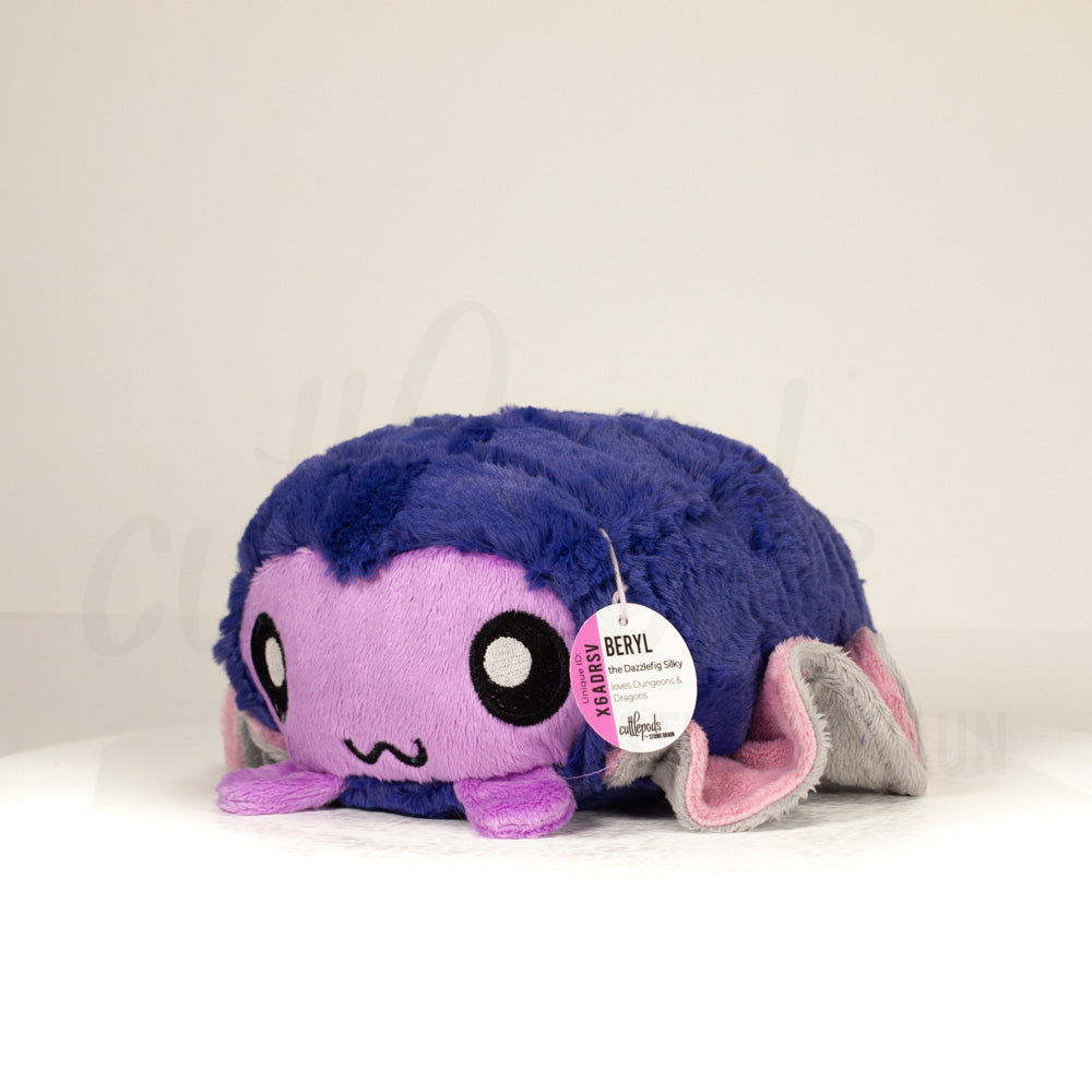 Front view of a cuttlepod plush toy, captured at a slight angle to highlight its charming features: large, cartoonish eyes, ruffled fins, and a cuddly, furry texture.