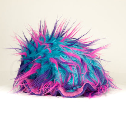 Slightly angled back view of a cuttlepod plush toy, highlighting two-tone ruffled fins, and a cuddly, furry body that comes to a soft point at the rear.