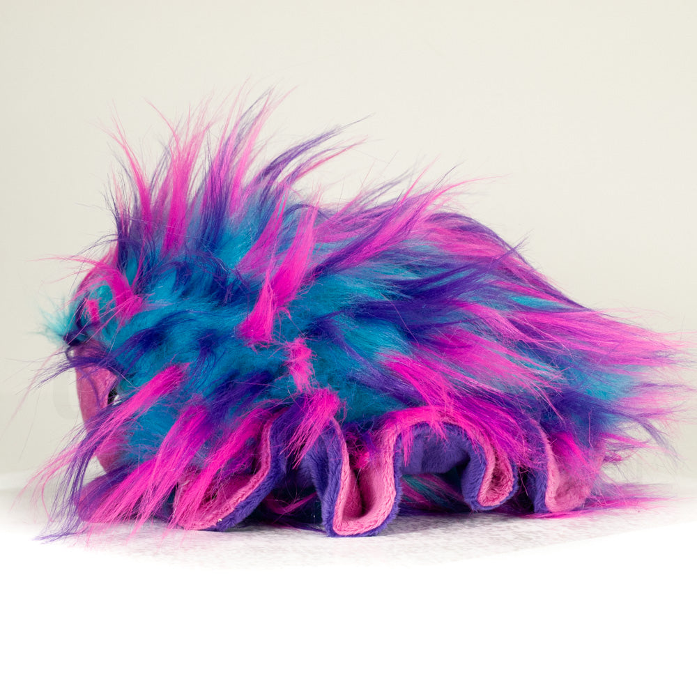 Side profile view of a cuttlepod plush toy, showcasing two-tone ruffled fins, and a cuddly, furry body.