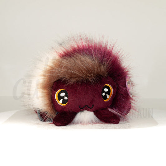 Front view of a cuttlepod plush toy, showcasing its unique form with large, cartoonish eyes, ruffled fins, and a cuddly, furry texture.