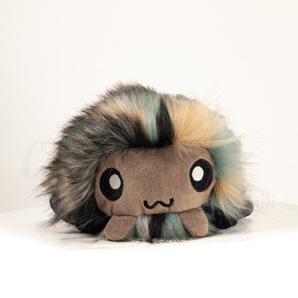 Front view of a cuttlepod plush toy, showcasing its unique form with large, cartoonish eyes, ruffled fins, and a cuddly, furry texture.