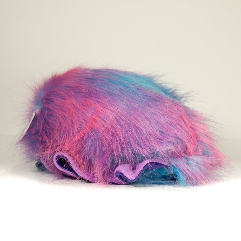 Slightly angled back view of a cuttlepod plush toy, highlighting two-tone ruffled fins, and a cuddly, furry body that comes to a soft point at the rear.