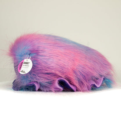 Side profile view of a cuttlepod plush toy, showcasing two-tone ruffled fins, and a cuddly, furry body.