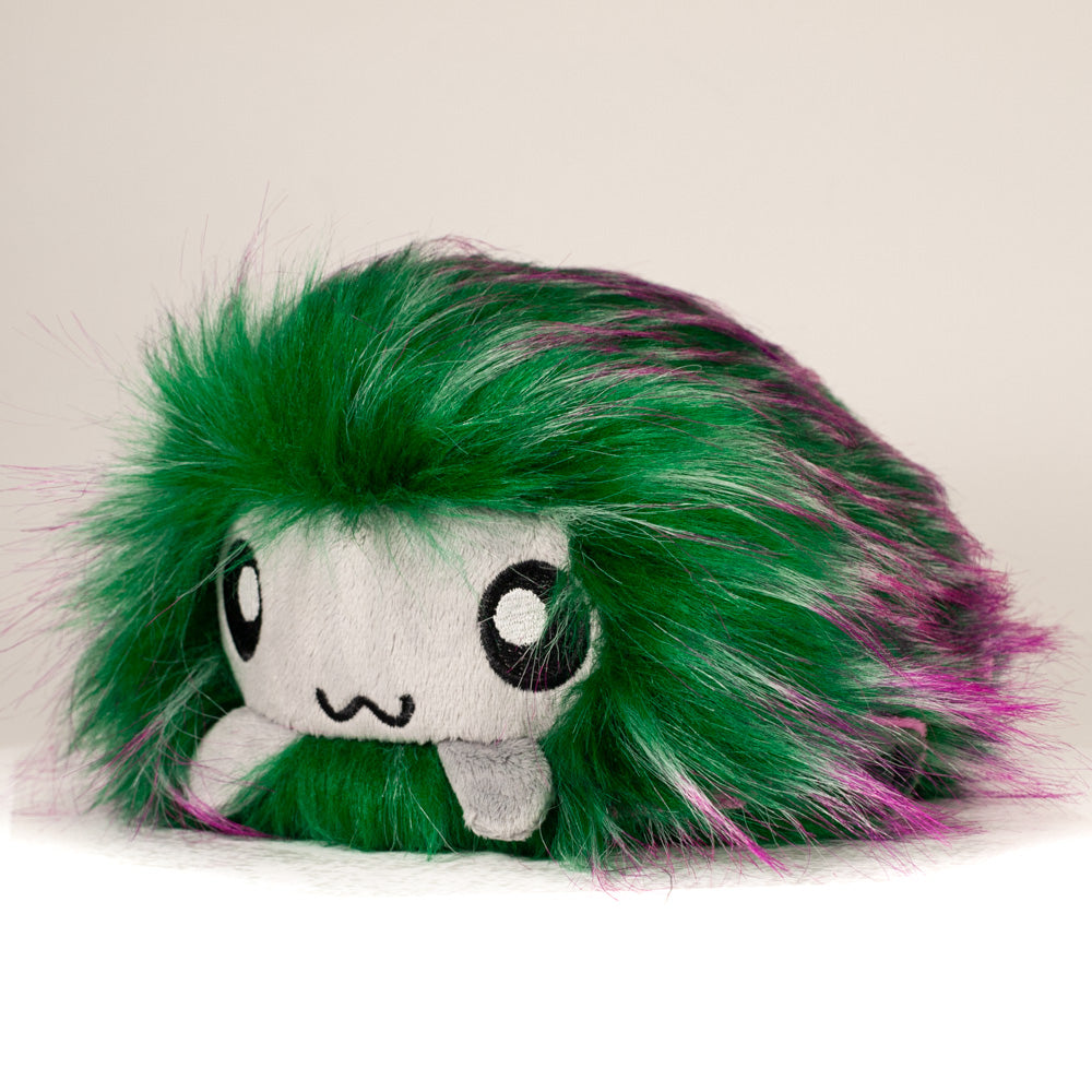 Front view of a cuttlepod plush toy, captured at a slight angle to highlight its charming features: large, cartoonish eyes, ruffled fins, and a cuddly, furry texture.