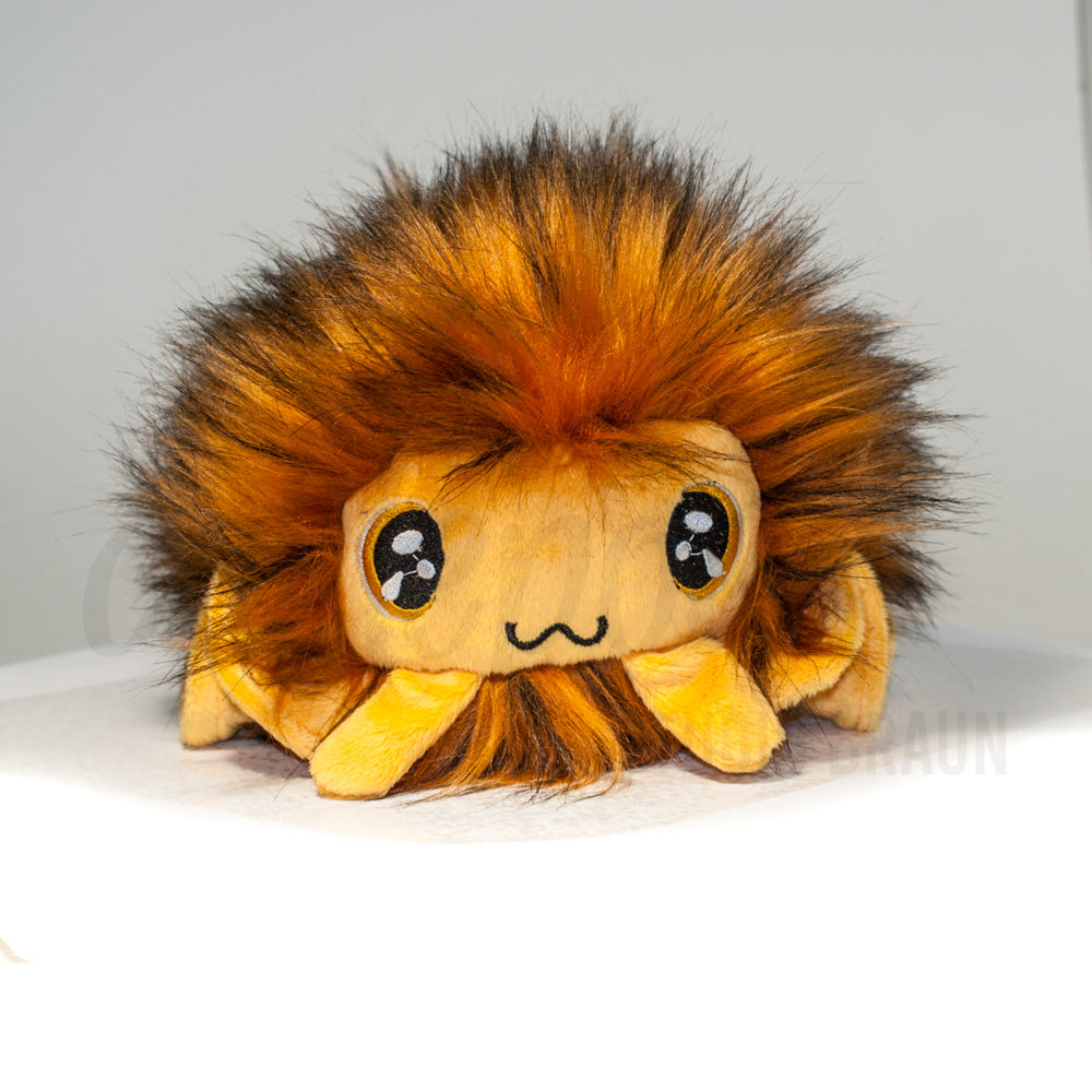 Front view of a cuttlepod plush toy, showcasing its unique form with large, cartoonish eyes, ruffled fins, and a cuddly, furry texture.