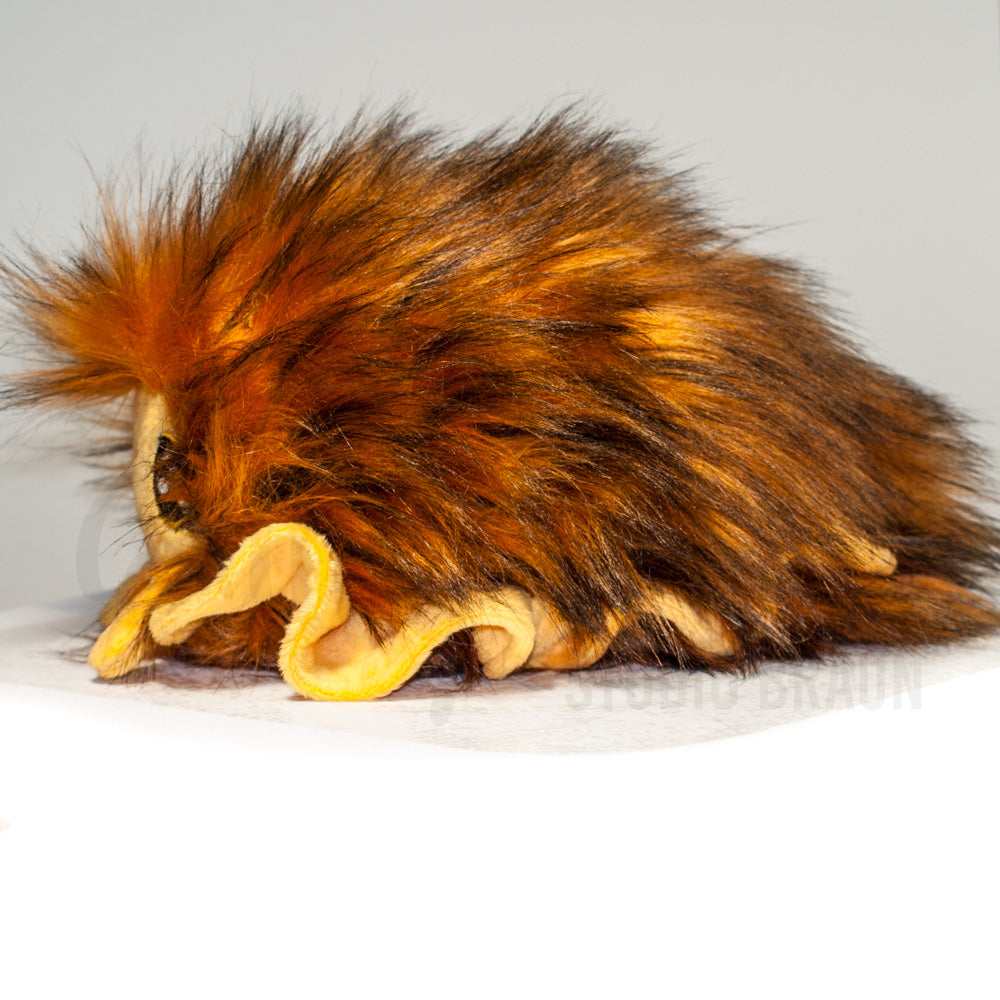 Side profile view of a cuttlepod plush toy, showcasing two-tone ruffled fins, and a cuddly, furry body.