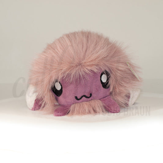 Front view of a cuttlepod plush toy, showcasing its unique form with large, cartoonish eyes, ruffled fins, and a cuddly, furry texture.