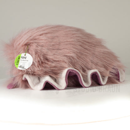 Side profile view of a cuttlepod plush toy, showcasing two-tone ruffled fins, and a cuddly, furry body.