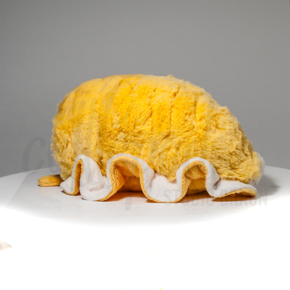 Slightly angled back view of a cuttlepod plush toy, highlighting two-tone ruffled fins, and a cuddly, furry body that comes to a soft point at the rear.