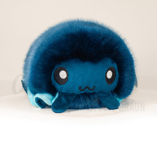 Front view of a cuttlepod plush toy, showcasing its unique form with large, cartoonish eyes, ruffled fins, and a cuddly, furry texture.