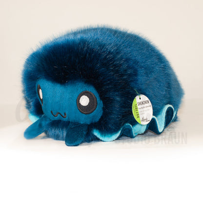 Front view of a cuttlepod plush toy, captured at a slight angle to highlight its charming features: large, cartoonish eyes, ruffled fins, and a cuddly, furry texture.