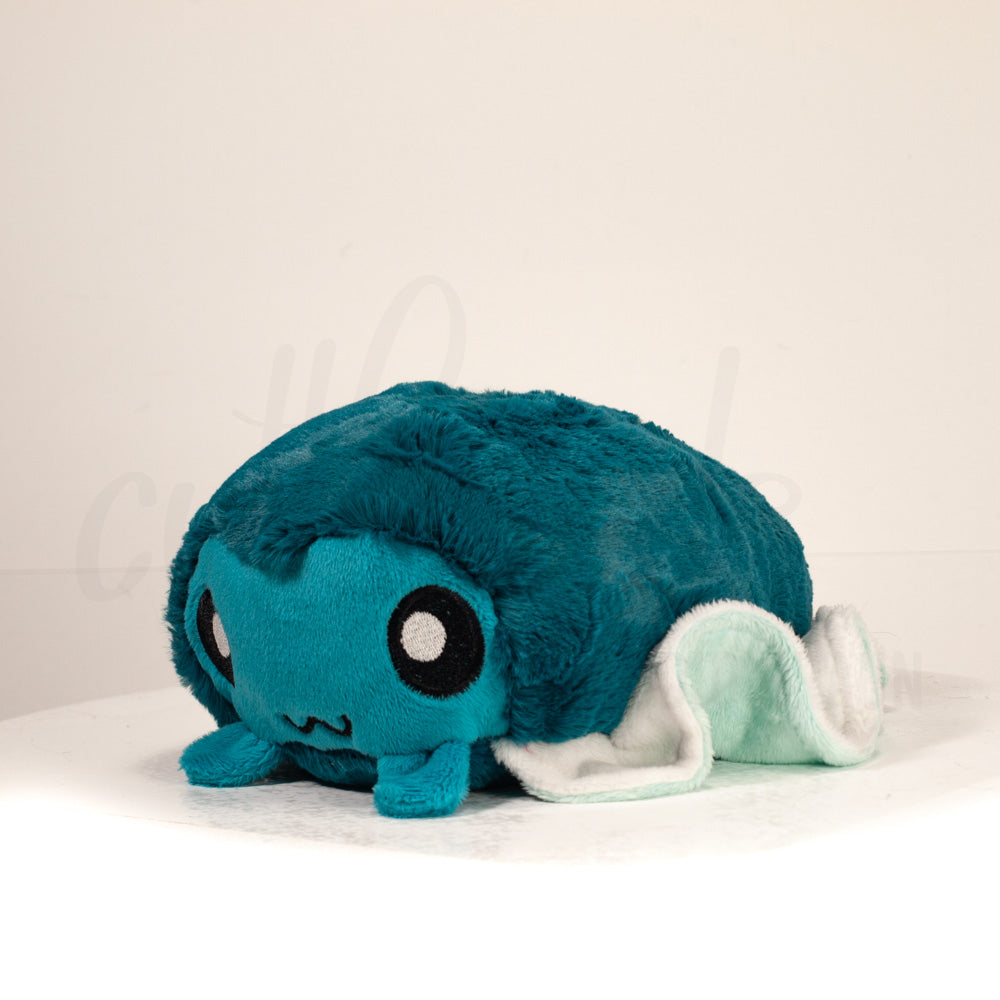 Front view of a cuttlepod plush toy, captured at a slight angle to highlight its charming features: large, cartoonish eyes, ruffled fins, and a cuddly, furry texture.