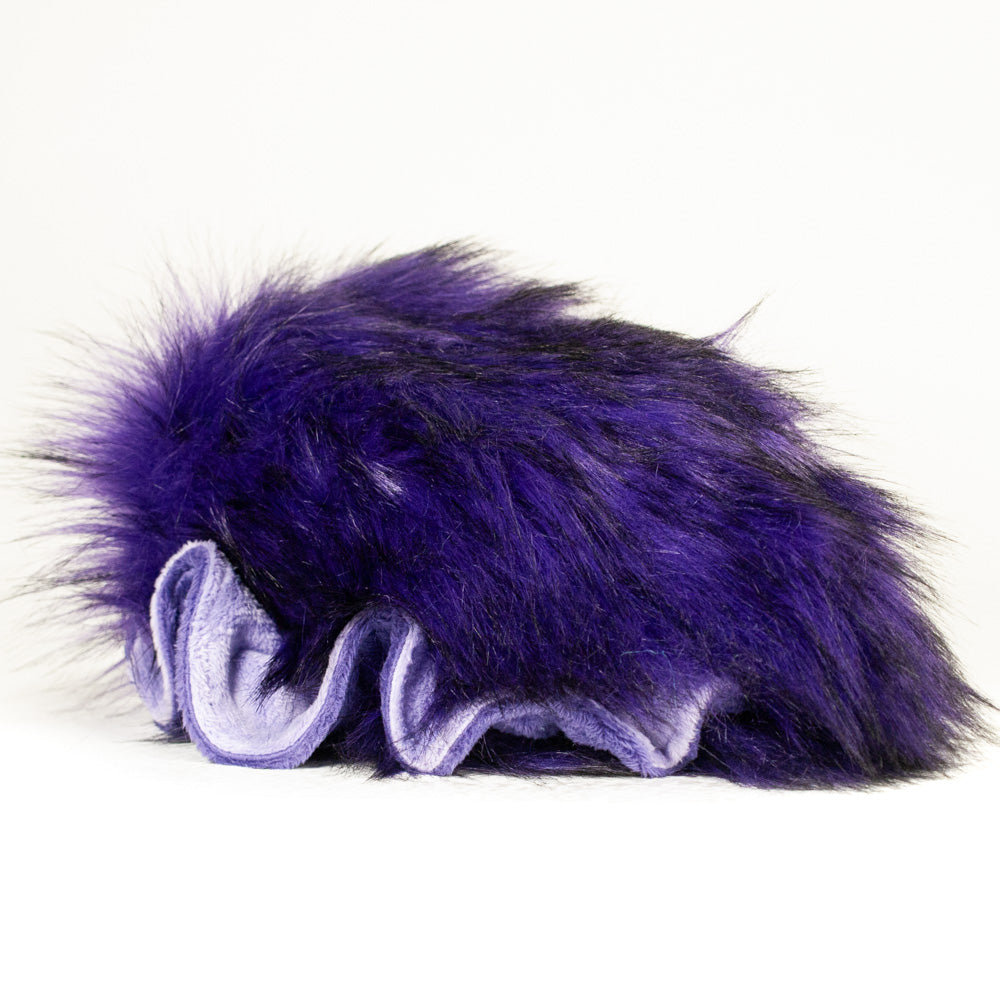 Slightly angled back view of a cuttlepod plush toy, highlighting two-tone ruffled fins, and a cuddly, furry body that comes to a soft point at the rear.