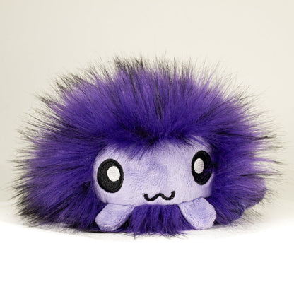 Front view of a cuttlepod plush toy, showcasing its unique form with large, cartoonish eyes, ruffled fins, and a cuddly, furry texture.