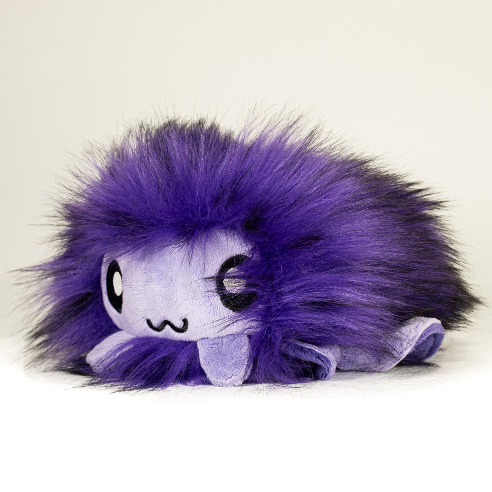 Front view of a cuttlepod plush toy, captured at a slight angle to highlight its charming features: large, cartoonish eyes, ruffled fins, and a cuddly, furry texture.