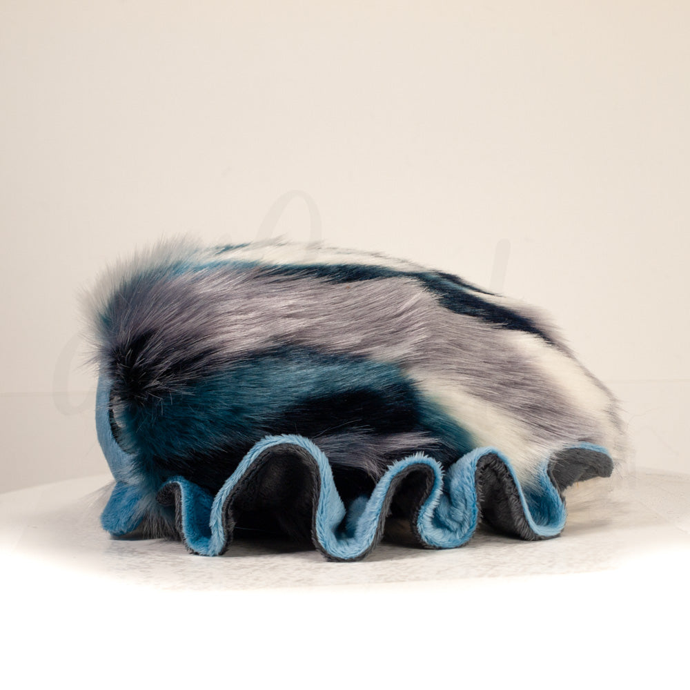 Side profile view of a cuttlepod plush toy, showcasing two-tone ruffled fins, and a cuddly, furry body.