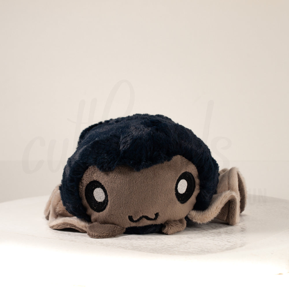 Front view of a cuttlepod plush toy, showcasing its unique form with large, cartoonish eyes, ruffled fins, and a cuddly, furry texture.