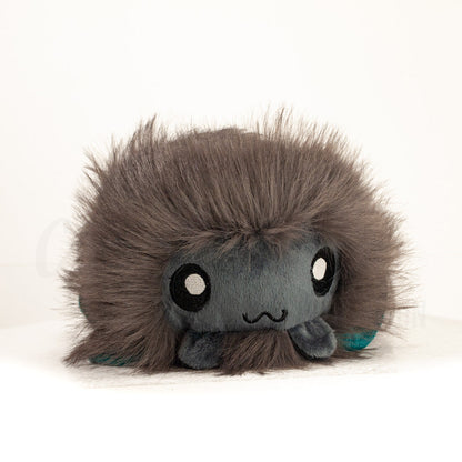 Front view of a cuttlepod plush toy, showcasing its unique form with large, cartoonish eyes, ruffled fins, and a cuddly, furry texture.