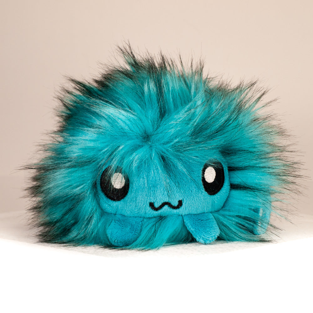 Front view of a cuttlepod plush toy, showcasing its unique form with large, cartoonish eyes, ruffled fins, and a cuddly, furry texture.