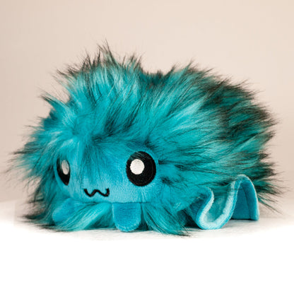 Front view of a cuttlepod plush toy, captured at a slight angle to highlight its charming features: large, cartoonish eyes, ruffled fins, and a cuddly, furry texture.