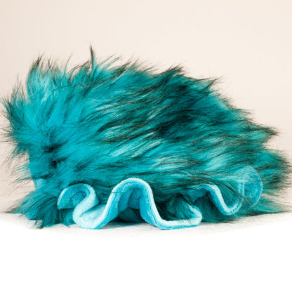 Side profile view of a cuttlepod plush toy, showcasing two-tone ruffled fins, and a cuddly, furry body.