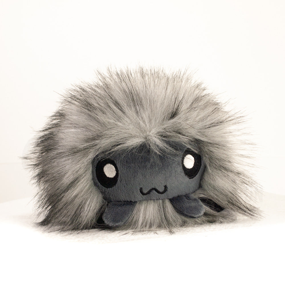 Side profile view of a cuttlepod plush toy, showcasing two-tone ruffled fins, and a cuddly, furry body.