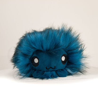 Front view of a cuttlepod plush toy, showcasing its unique form with large, cartoonish eyes, ruffled fins, and a cuddly, furry texture.