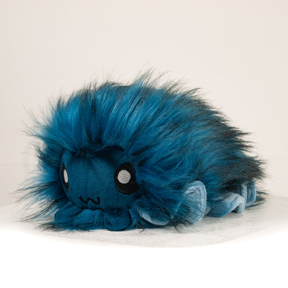 Front view of a cuttlepod plush toy, captured at a slight angle to highlight its charming features: large, cartoonish eyes, ruffled fins, and a cuddly, furry texture.