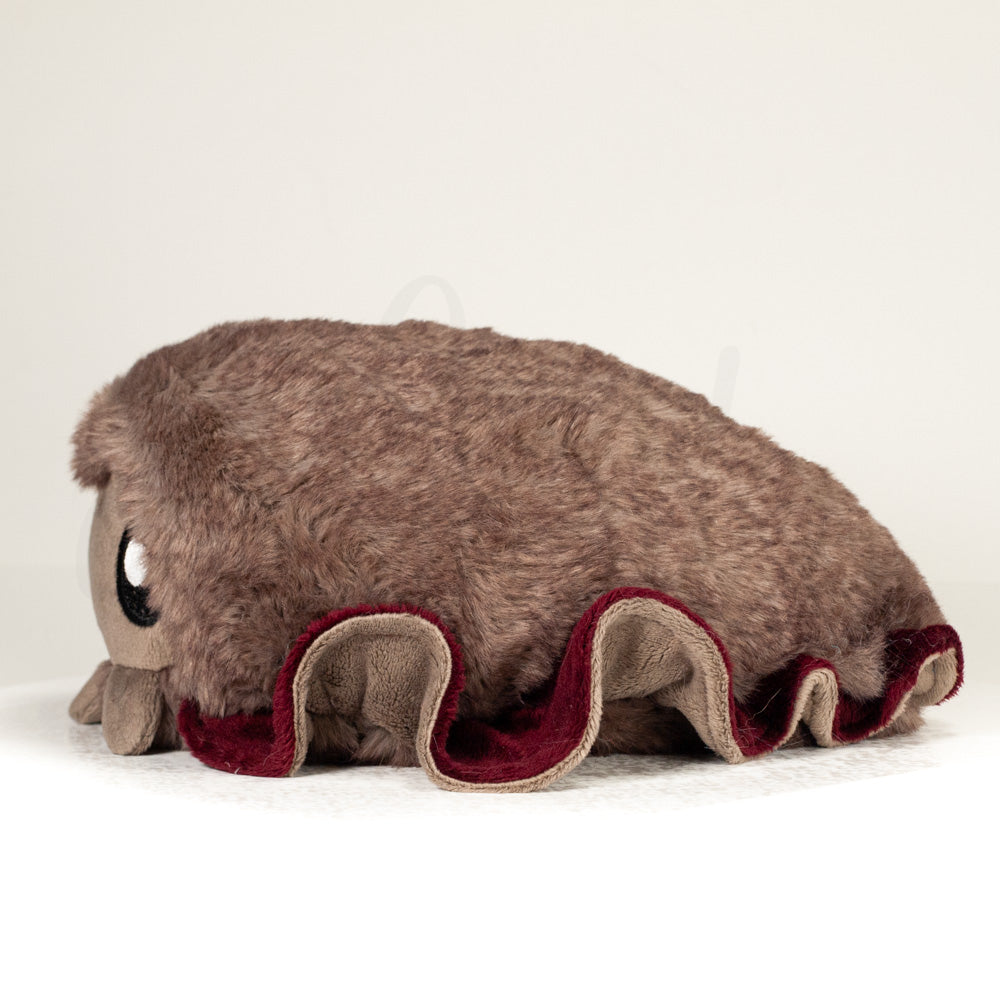 Side profile view of a cuttlepod plush toy, showcasing two-tone ruffled fins, and a cuddly, furry body.