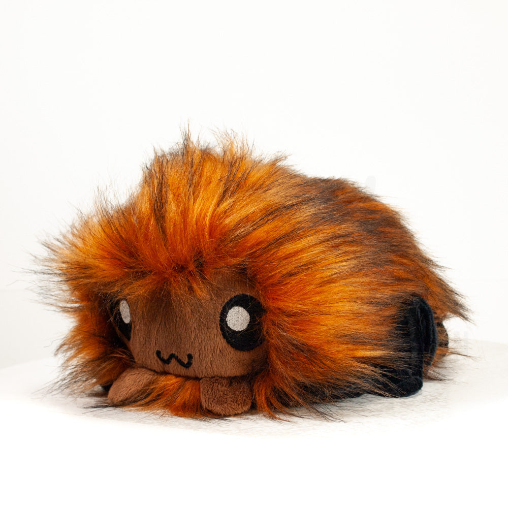 Front view of a cuttlepod plush toy, captured at a slight angle to highlight its charming features: large, cartoonish eyes, ruffled fins, and a cuddly, furry texture.