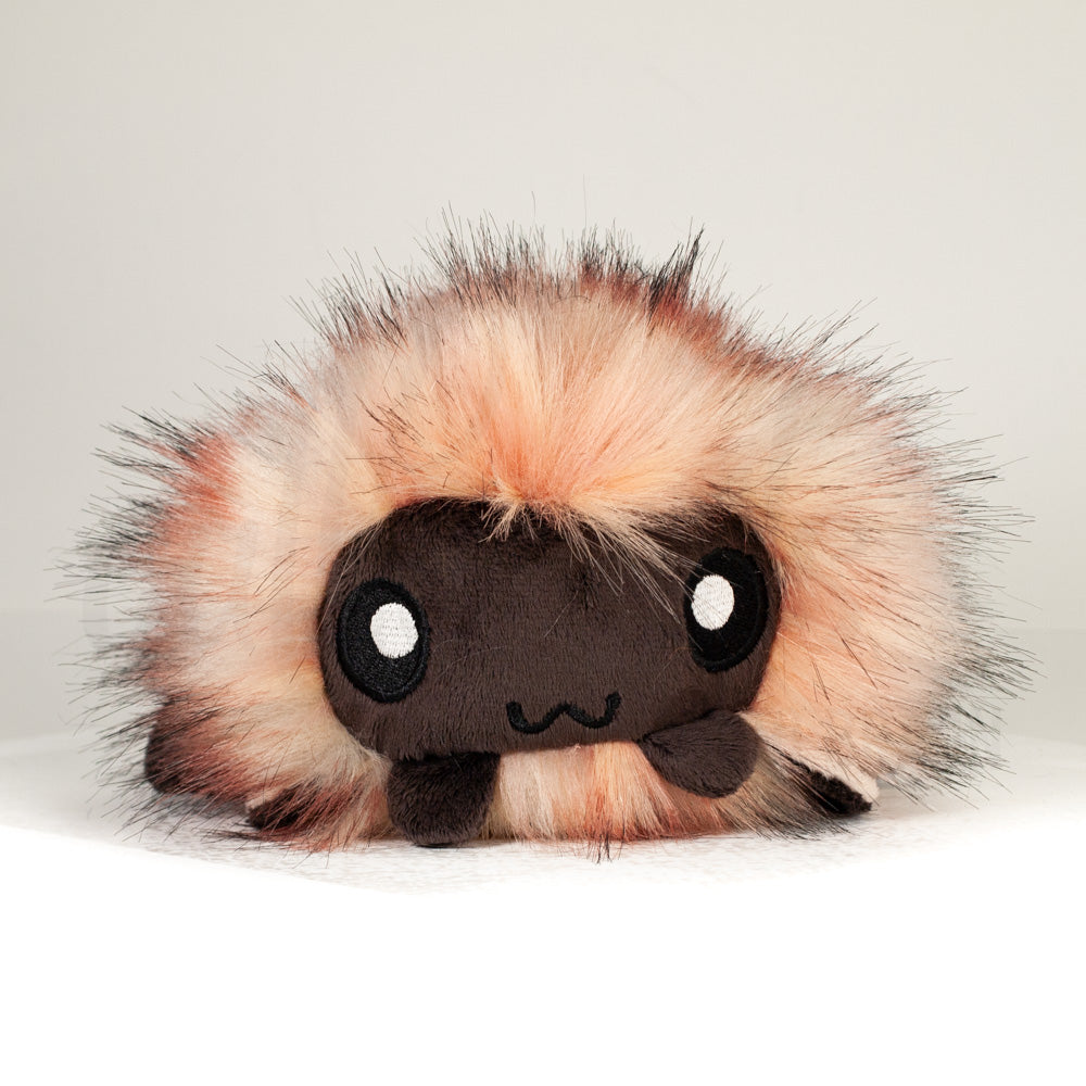 Front view of a cuttlepod plush toy, showcasing its unique form with large, cartoonish eyes, ruffled fins, and a cuddly, furry texture.